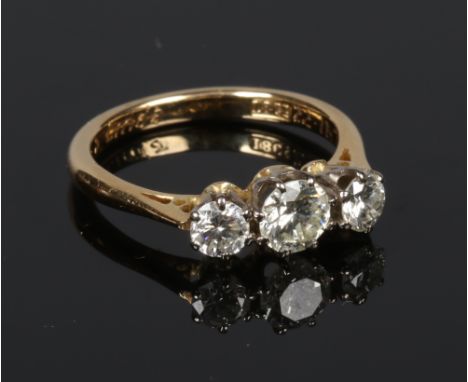 An 18 carat gold three stone diamond ring. Claw set with three graduated brilliant cut diamonds. Principle stone 0.52ct, gros