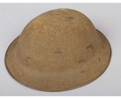 A World War I Mk 1 Brodie helmet. Stamped FKS No. 78. With folded rim, original sand paint, liner and leather chin strap.  Go
