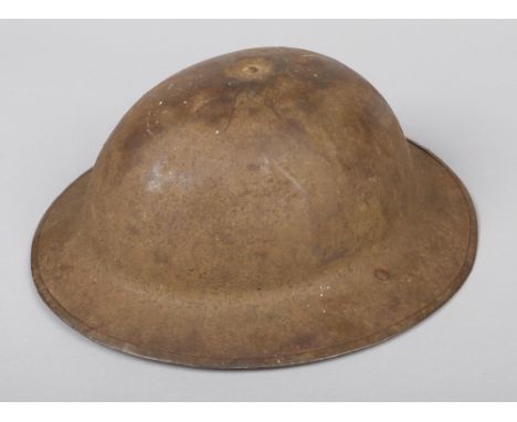 A World War I Brodie helmet. Stamped FKS No. 4. With leather liner and strap, having folded rim and retaining some original s