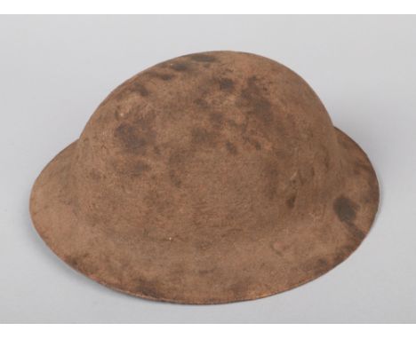 A World War I War Office pattern Model A Brodie helmet. With raw edge, original sand paint, liner and chin strap.  Good origi