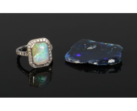 An Art Deco white gold, opal and diamond ring. Set with a canted rectangular opal under a border of 26 diamonds, with seven d