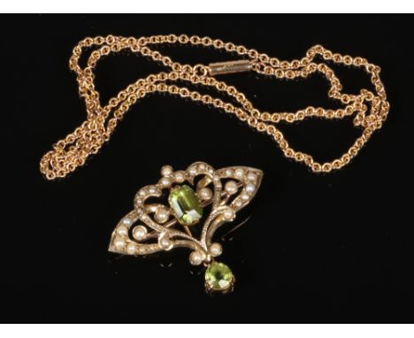 An Edwardian 9 carat gold openwork peridot and seed pearl brooch with a central lower drop and a 9 carat gold necklace. Gross
