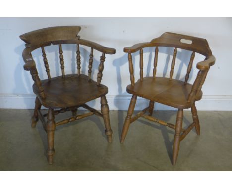 A Victorian elm smokers bow or Captains chair and a similar reproduction chair 