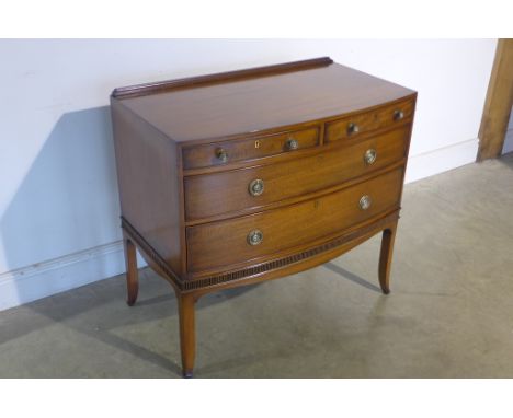 A Victorian mahogany bow fronted two over three chest of drawers, bares a plaque in brass reading By appointment to the Queen