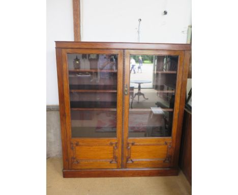 A large late Victorian cabinet bookcase with adjustable shelves with two geometric panel glazed doors - Height 168cm x 150cm 