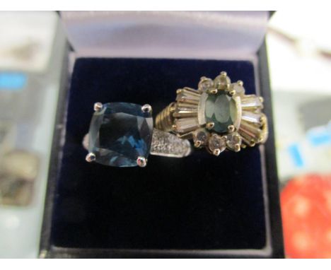 A 9ct yellow gold ring set with a light blue stone surrounded by baguette and brilliant cut white stones and a 9ct gold solit
