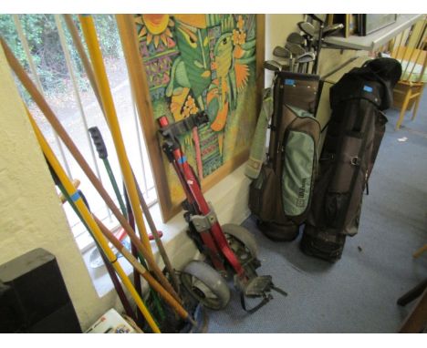 A set of Wilson golf clubs, two golf bags and a trolley, along with a selection of vintage garden tools 