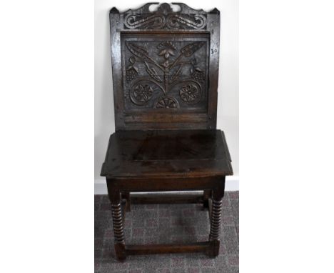 A late 17th century oak back stool with carved panel, plank seat and turned front legs united by stretchers, height 101cm.Add