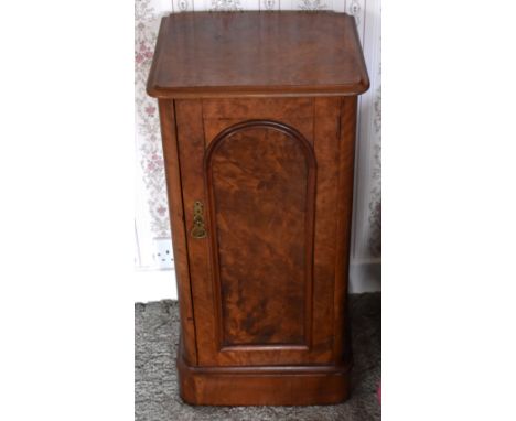 A Victorian figured walnut pot cupboard with moulded rectangular top above arched panel door enclosing a single shelf raised 