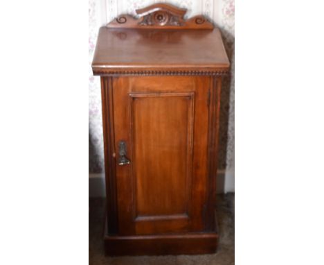 A late Victorian walnut pot cupboard with raised back above single panel cupboard door enclosing a shelf and raised on a plin