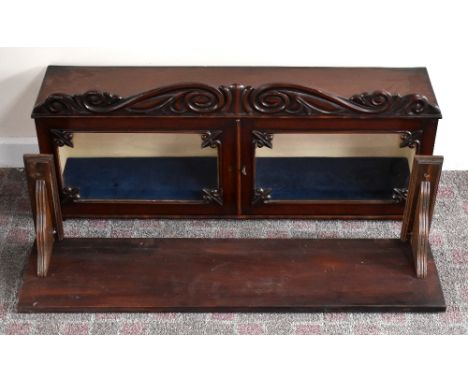 An early Victorian mahogany cabinet with carved pediment above two glazed doors mounted on an associated shelf, width 93cm, d