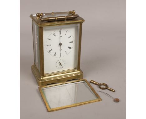 A brass carriage alarm clock with open top escapement. 