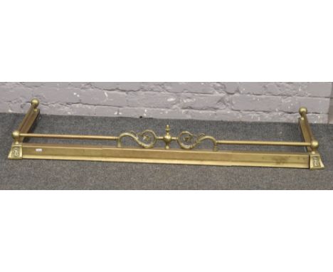 A Victorian adjustable brass fire fender with central floral design and foot rail. 