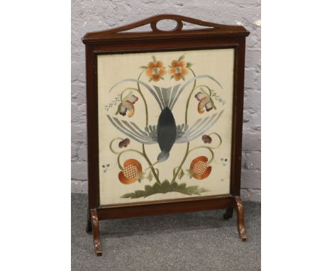 A mahogany framed fire screen with embroidered glazed panel. 