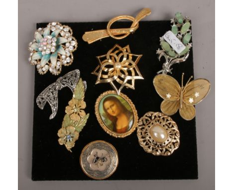 Ten vintage costume jewellery brooches including Mona Lisa portrait and marcasite example. 