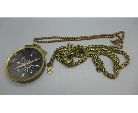 A collection of commemorative coins including seven £5 coins, bank notes and a large compass 
