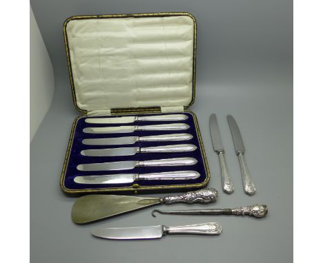 A cased set of silver handled knives, three other silver handled knives, a silver handled button hook and shoe horn 