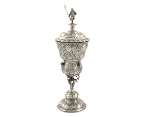 A 19th century German silver standing cup and cover, tapering baluster form, embossed decoration, the finial of the pull-off 