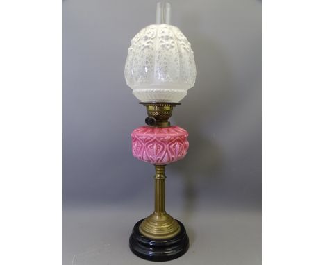 VICTORIAN OIL LAMP with pink moulded glass font and relief moulded globular shade, 66cms overall H