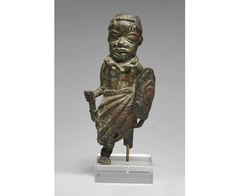 A Benin standing warrior figureNigeriabronze, holding a shield and the base of a staff, wearing a coral necklace and a robe,1