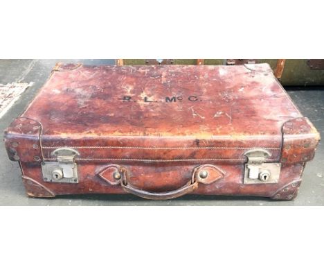 A vintage leather suitcase with leather corner bracings, the top monogrammed R. L. McC., 73cmW 
