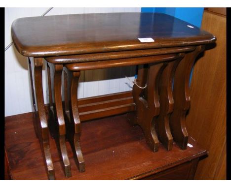 A nest of three Ercol tables with trestle ends 
