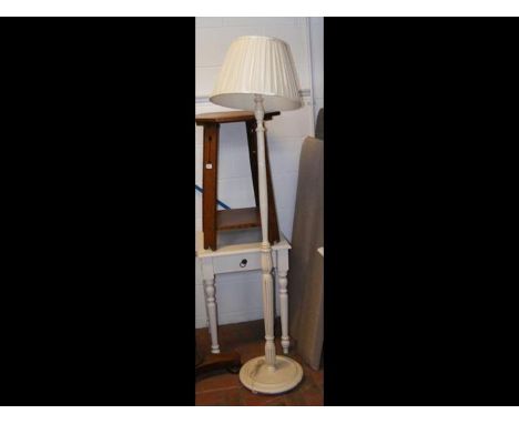 A standard lamp, together with a white side table 