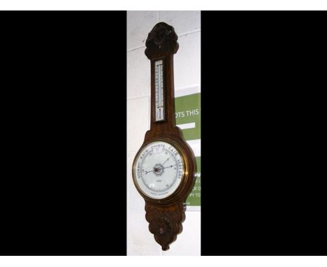 An oak framed banjo shaped barometer and thermometer 