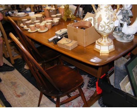 An Ercol table with trestle ends, together with the four stick back dining chairs - table length 150cms