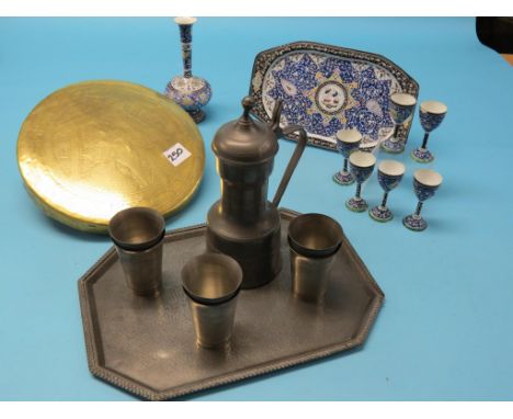 A Persian enamel liqueur set, six goblets, tray and vase, bright painted designs against a blue ground, together with a pewte