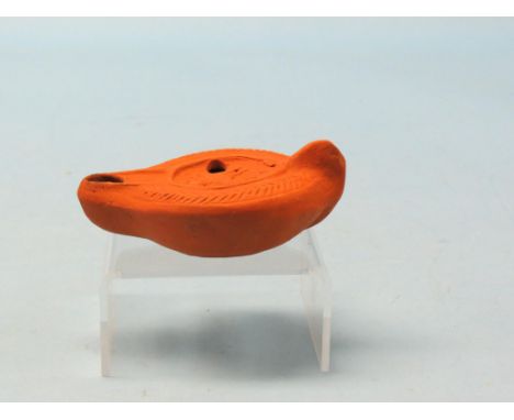 A Roman terracotta oil lamp, with relief-moulded and incised detail, circa 4th century, 4.75in. long