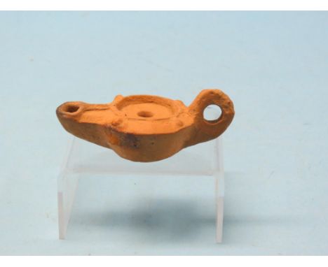 A Roman terracotta oil lamp, circa 43-400AD, 4.25in. long - discovered at Chichester, West Sussex