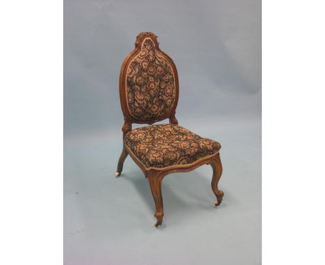 A Victorian walnut drawing-room single chair, frame carved with leaf-scrolls, on front cabriole legs with casters, machine ta