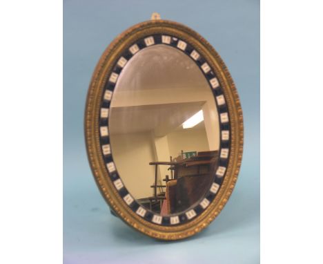 A 19th century Irish-style mirror, oval-shape with moulded gilt surround, inset with a narrow border of two-colour opaque gla