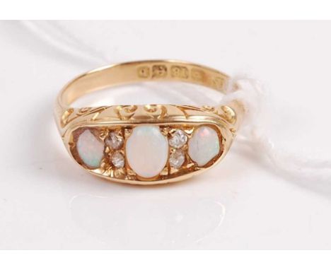 A vintage 18ct gold opal and diamond ring arranged as three cabochon opals each dispersed with two diamond highlights, 3.2g, 