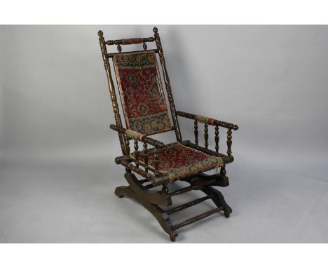 A Late Victorian Mahogany Spindle Framed American Rocking Chair with Tapestry Seat and Back, in Need of Some Attention 