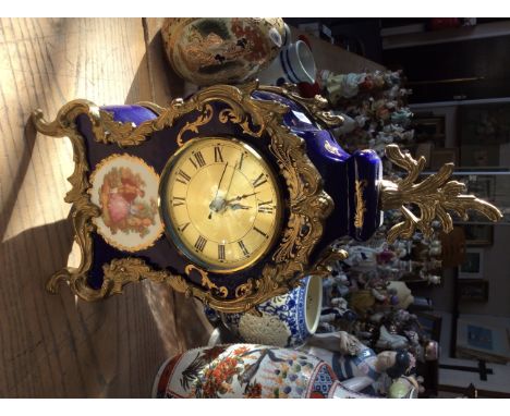 A blue and gilt mantle clock with floral decoration.