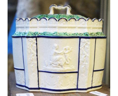 An 18th Century salt glazed Staffordshire tied caddy with figure decoration to panels of body with blue and green detailing a