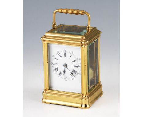 An early 20th Century French brass carriage clock with bevelled edge glass panels and top, the white enamel face having black