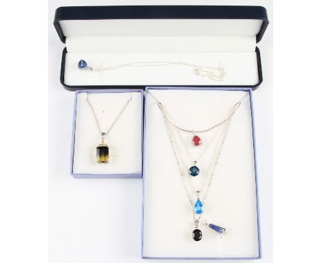 A lot to include a ruby pendant, a blue topaz pendant, a black stone pendant, a blue stone pendant, a bi-coloured quartz pend