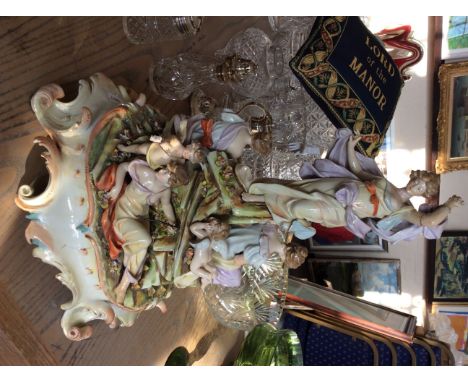 A decorative ceramic centrepiece with various moulded figures to include playful cherubs and a reclining lady. A/F