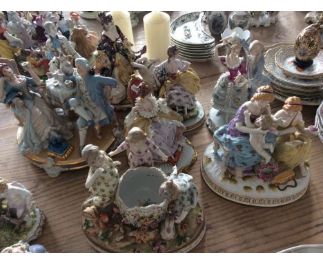 Eight ceramic figurines, one with vase surrounded by three children and three with intricate frill detail.