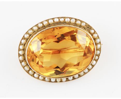 A yellow metal citrine and seed pearl pin brooch, the oval cut citrine surrounded by a border of seed pearls (A/F one pearl m