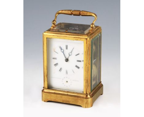 An early 20th Century brass carriage clock with twin barrel movement with bevelled edge glass panels and top, the white ename