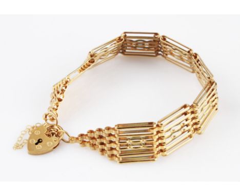 A 9ct yellow gold gate bracelet, six links wide, with safety chain, hallmarked Birmingham 1991, with heart padlock clasp, hal