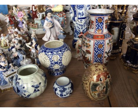 Four oriental ceramic vases, one with cut design and a decorative oriental egg.