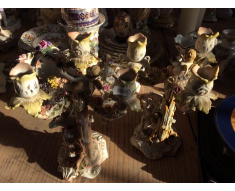 Two ceramic candlesticks with figurines, gilded flower detail.