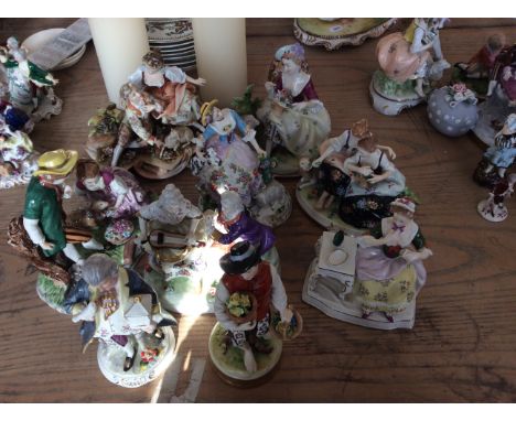 Nine ceramic figurines with gilded detailing including man with bird and girl with drink.