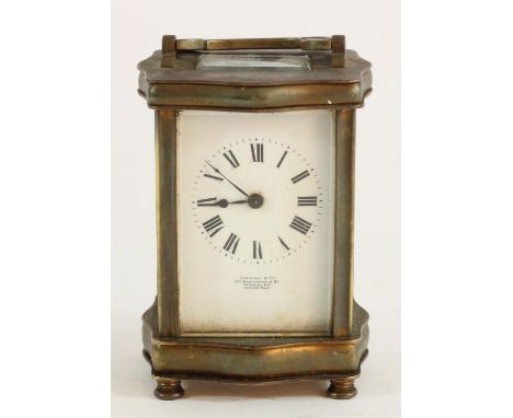 A French brass carriage clock, with serpentine shaped case, beveled edge glass panels and door, white enameled dial with roma