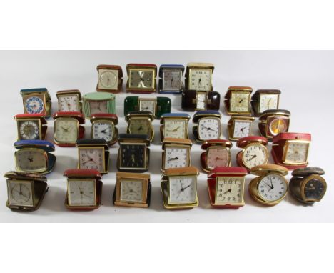 A large collection of mid 20th Century travel alarm clocks, together with Smiths wall clocks, barometers and clock cases (5) 